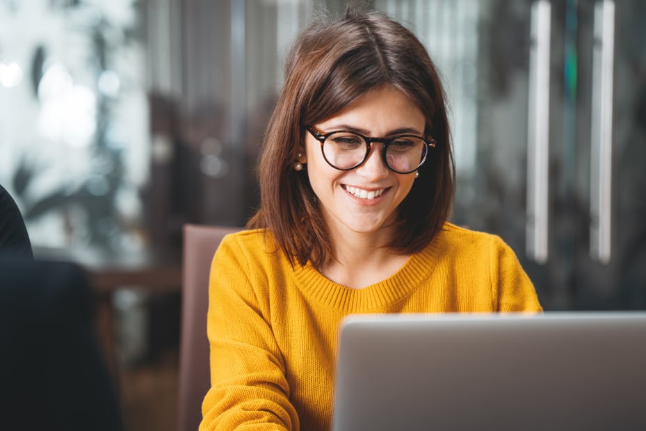 A female employee searches for ways to improve health and wellness programs using a laptop.