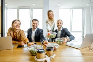 Group of employees reaching for salads