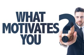 Business man pointing the text What Motivates You