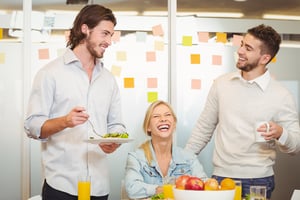 Employees having fun during breakfast in creative office