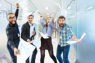 Group of joyful excited business people throwing papers and having fun in office.jpeg