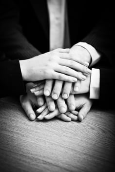 Image of business partners hands on top of each other symbolizing companionship and unity-1
