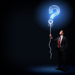 Image of businessman in black suit against dark background.jpeg