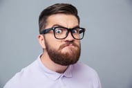 Portrait of a funny hipster man looking at camera over gray background.jpeg