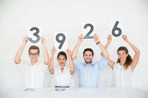 Portrait of panel judges holding score signs in office.jpeg