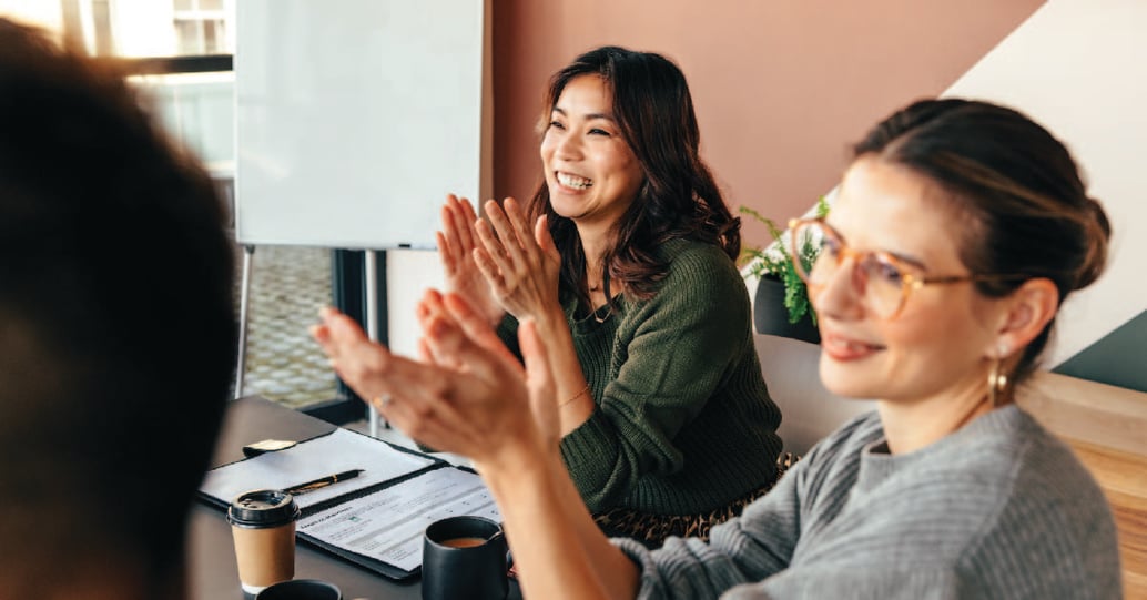 Two office workers clapping