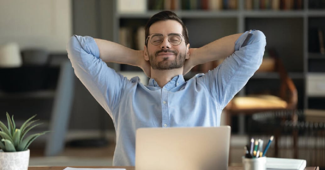 Man relaxing and practicing mindfulness at work from home desk