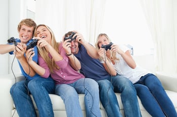 A group of friends leaning to the side as they play video games together.