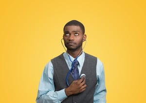 Closeup portrait executive man, business person, worker listening to his heart with stethoscope looking up isolated yellow background. Preventive medicine, financial condition concept. Face expression-1