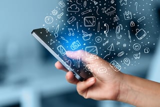 Hand holding smartphone with hand drawn media icons and symbols concept.jpeg