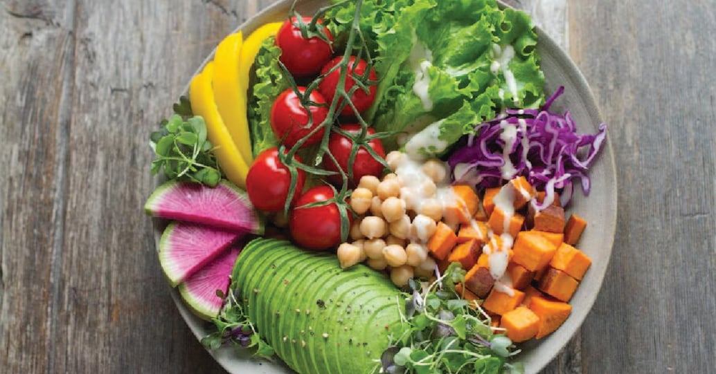 salad bowl with avocado, chickpeas, sweet potato, cabbage, tomato, and lettuce