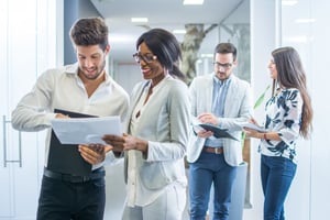 4 employees meeting and reviewing paperwork