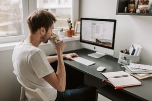 man sipping coffee at desk